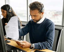 Man with headset reading notes